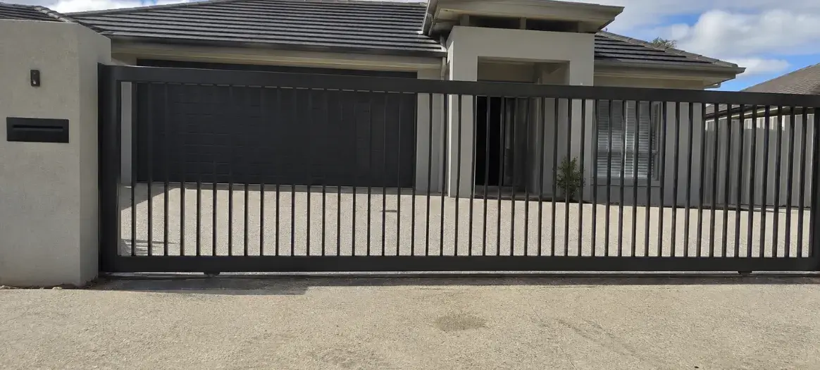 A black aluminium gate at the entrance of a driveway in Mount Lofty